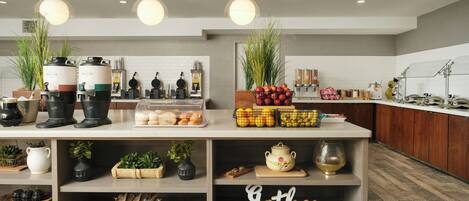 Una cocina moderna con una isla central, varios electrodomésticos y un letrero que dice 'Gather' en el estante inferior.