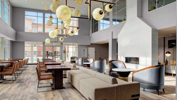 A spacious lobby with a long dining table, comfortable seating, and a modern chandelier. - Fairfield by Marriott Inn & Suites Boulder Broomfield/Interlocken (Broomfield)