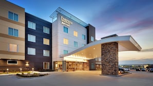 Un hôtel Fairfield Inn & Suites Marriott au design moderne, doté d’une entrée imposante et d’un parking.