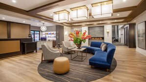 A modern lobby with a reception desk, seating area, and a fireplace. - Homewood Suites by Hilton Saratoga Springs (Saratoga Springs)
