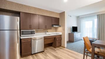 Una cocina moderna con electrodomésticos de acero inoxidable, armarios de madera y microondas integrado.