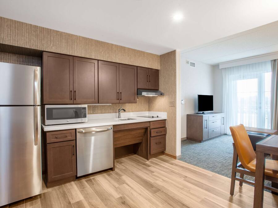 Una cocina moderna con electrodomésticos de acero inoxidable, armarios de madera y microondas integrado.