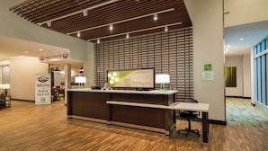 Eine Rezeption mit Holiday Inn Schild, Holzboden und Check-in-Schalter.