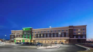 A Holiday Inn hotel with a parking lot and a well-lit facade.
