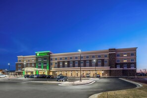 Un hôtel Holiday Inn doté d’un parking et d’une façade bien éclairée.