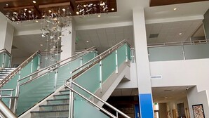 A modern interior with a glass staircase, metal railings, and a decorative ceiling light fixture. - Holiday Inn Express & Suites Denver - Aurora Medical Campus by IHG (Aurora)