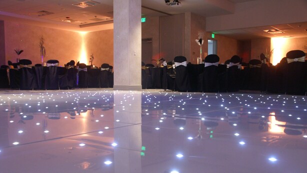 A room with rows of tables and chairs, some with black covers and white sashes. - Holiday Inn Express & Suites Denver - Aurora Medical Campus by IHG (Aurora)