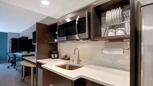 Una cocina moderna con un microondas de acero inoxidable, un lavaplatos y un refrigerador.
