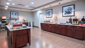 A spacious kitchen area with wooden cabinets, a central island, and various appliances.