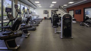 A gym with treadmills, elliptical machines, and weight machines.
