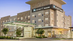 A multi-story hotel with a stone facade, a covered entrance, and a sign reading "HYATT house". - Hyatt House Bryan/College Station (Bryan)