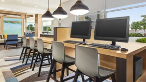 A modern office space with two monitors, a wooden desk, and a view of the outdoors. - Hyatt House Bryan/College Station (Bryan)