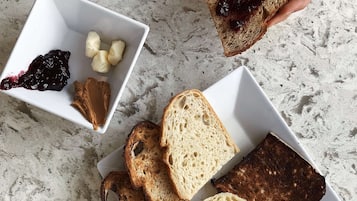 A table with various food items including bread, butter, jam, and cheese.