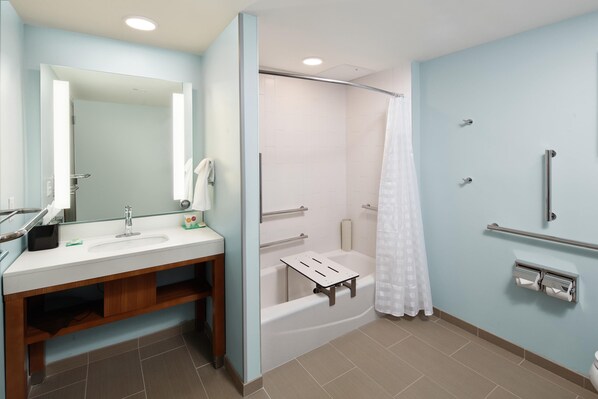 A modern bathroom with a sink, mirror, shower, and grab bars. - Hyatt Place Knoxville Downtown (Knoxville)
