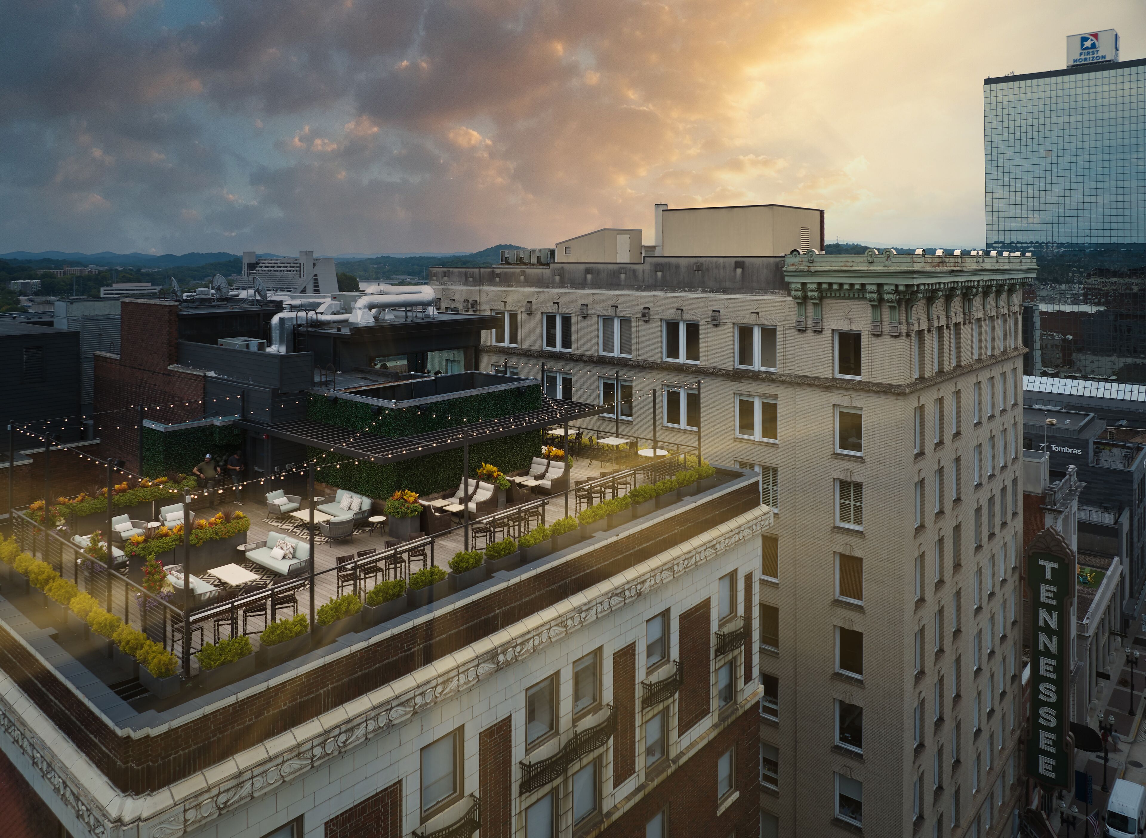 Terraço no telhado com área de estar ao ar livre e vista para a paisagem urbana.
