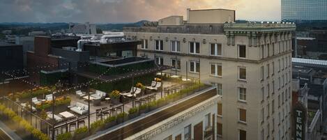 A rooftop terrace with outdoor seating and a view of the cityscape.