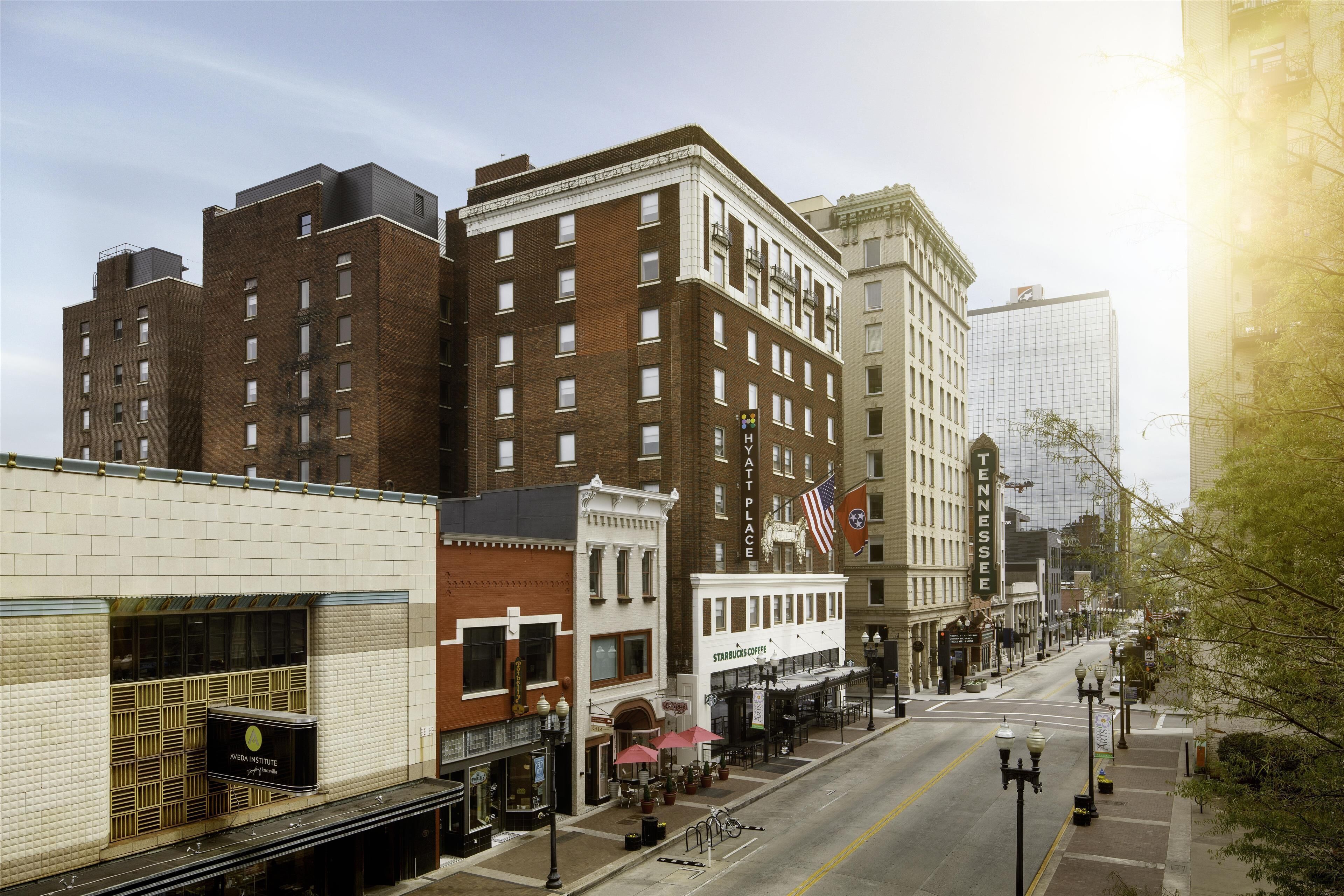 A street view with a mix of historic and modern buildings, including a Starbucks and a building with a sign that reads "Tennessee".