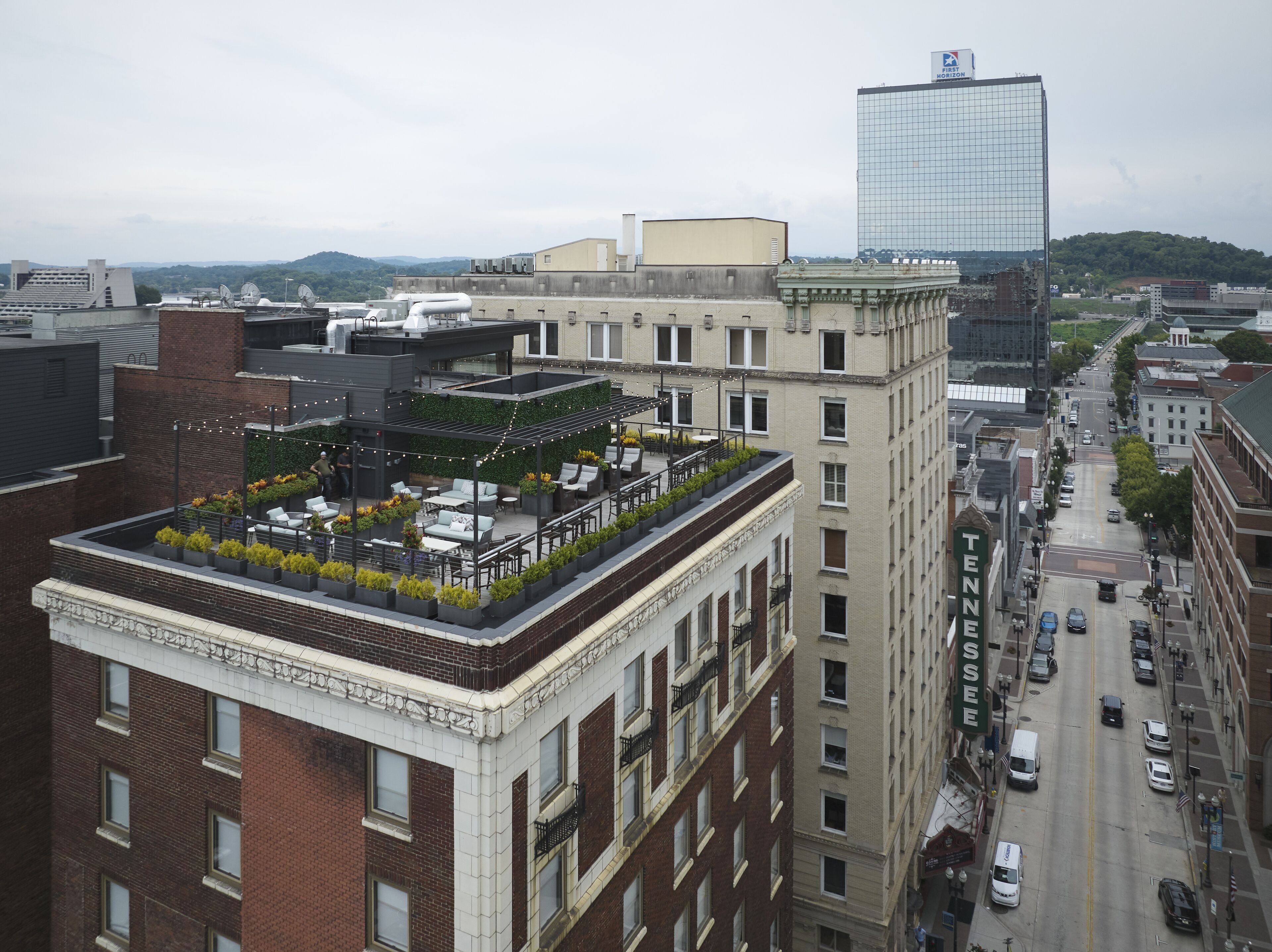 A rooftop terrace with outdoor seating and a view of the cityscape.