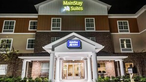 Un hôtel MainStay Suites avec une façade en briques, une grande entrée et une enseigne au-dessus de l’entrée.