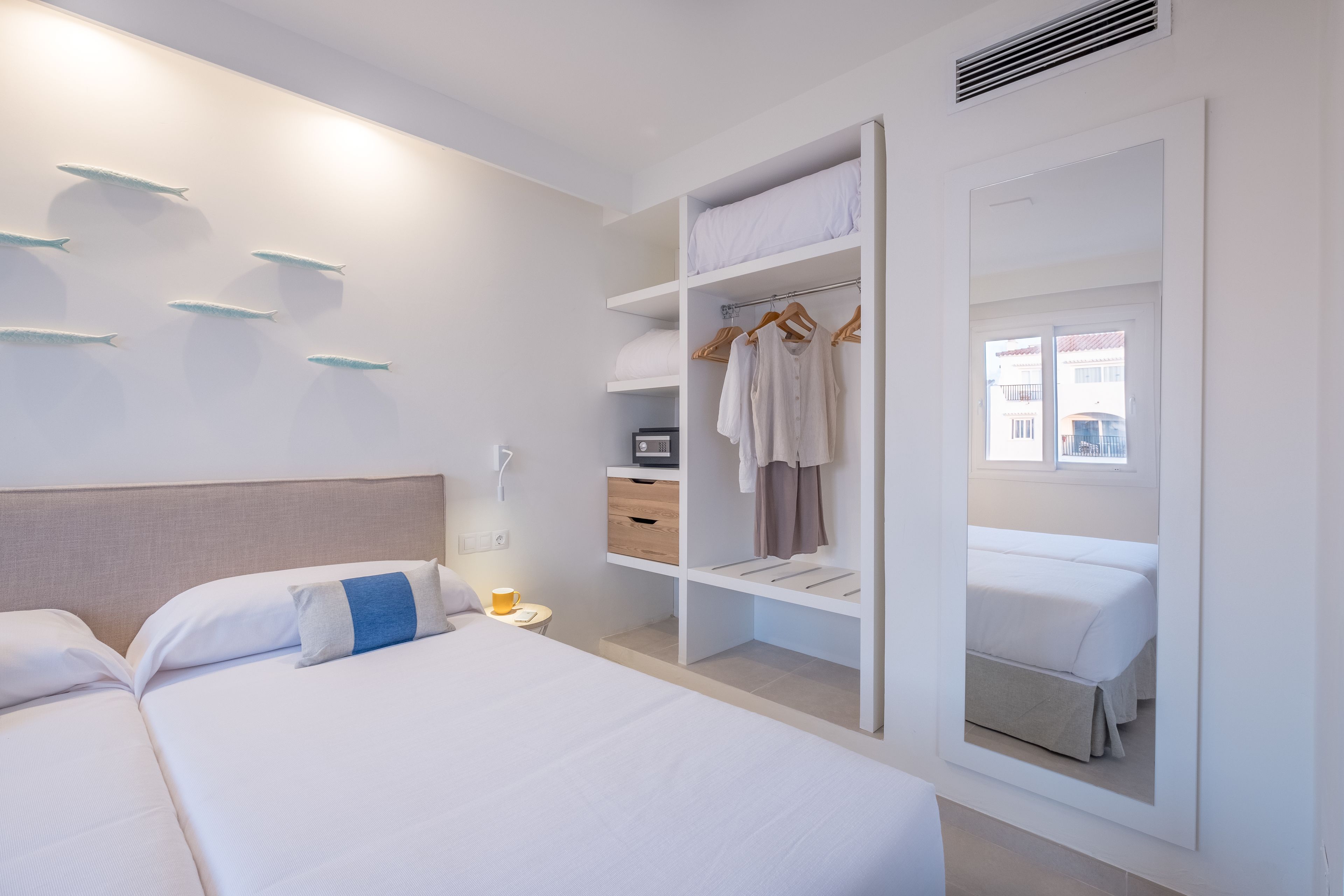 Une chambre d’hôtel comprenant un lit, une armoire et un bureau avec une chaise.