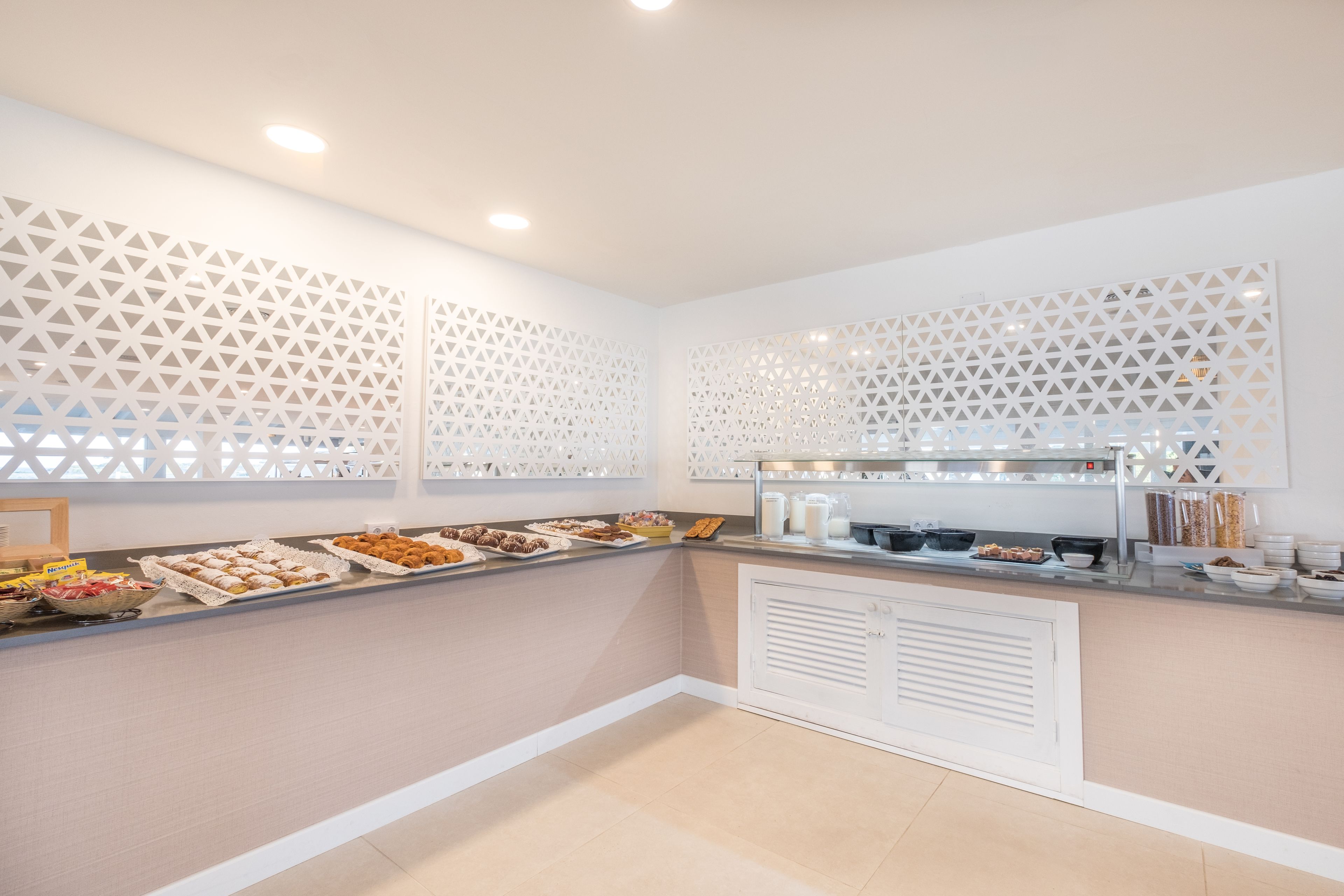 A buffet area with a variety of food items and a white decorative partition.