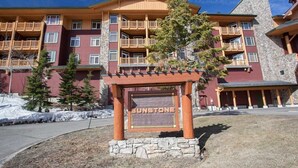 A multi-story building with a stone facade and wooden balconies. - Sunstone 329 (Mammoth Lakes)