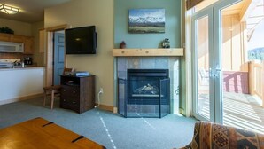 A living room with a fireplace, a television, and a dining area. - Sunstone 329 (Mammoth Lakes)