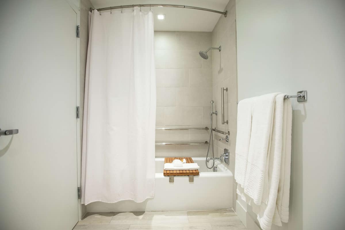 A modern bathroom with a shower, a bathtub, and a toilet.