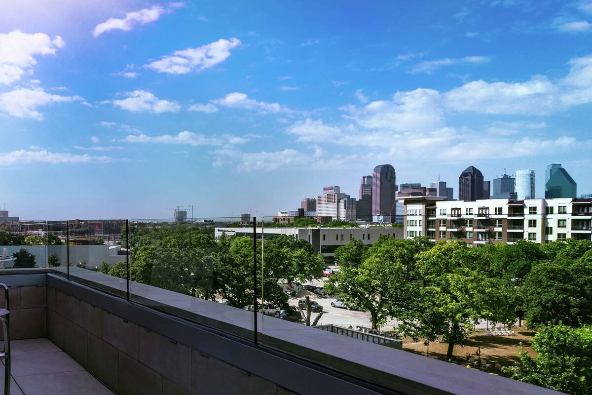 A balcony with chairs and a city view.