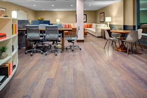 A modern hotel room with a wooden floor, a dining area with a table and chairs, a sofa, and a bookshelf. - Residence Inn by Marriott Boulder Broomfield/Interlocken (Broomfield)