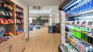A hotel lobby with snack shelves, a seating area, and a refrigerated beverage section. - Maritime Hotel Fort Lauderdale Airport & Cruiseport (Fort Lauderdale)