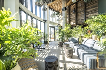 A bar area with wooden furniture, multiple shelves of bottles, and stools. at Made Hotel