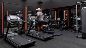 A gym with treadmills, weight machines, and a mirrored wall. - Hotel Savoy Kansas City, Tapestry Collection by Hilton (Kansas City)