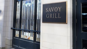 A building facade with a sign reading "SAVOY GRILL" and a black metal gate. - Hotel Savoy Kansas City, Tapestry Collection by Hilton (Kansas City)