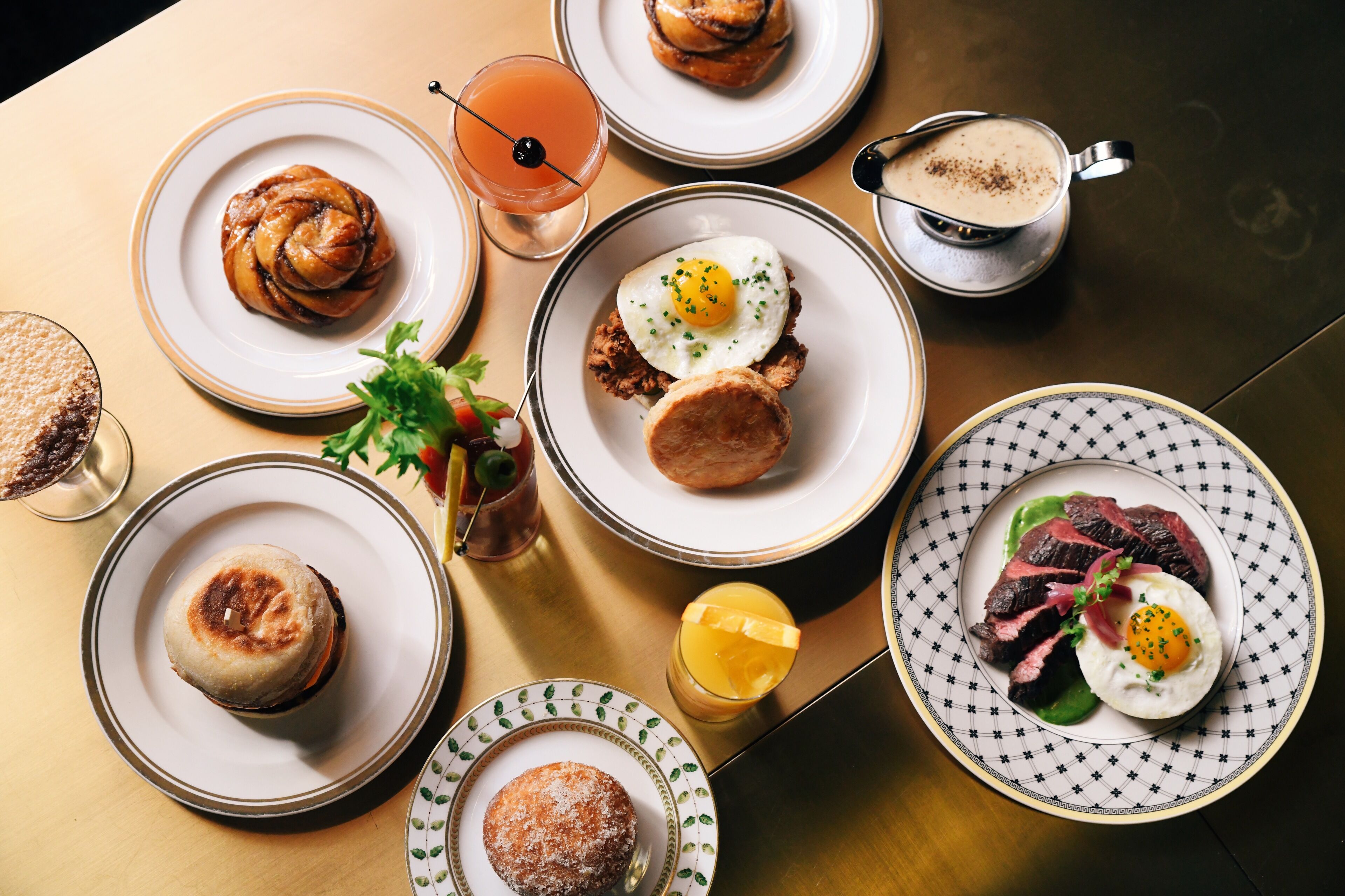 Una mesa con diferentes opciones de desayuno, como pasteles, huevos y un plato de carne.