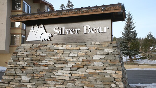 Une enseigne pour « Silver Bear », avec une illustration d’un ours et un motif de montagne.
