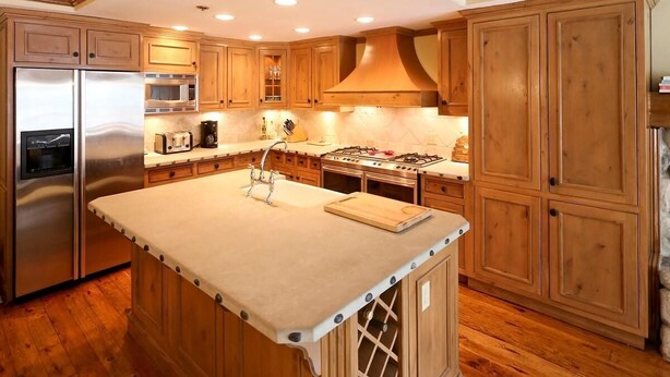 Una cocina con armarios de madera, electrodomésticos de acero inoxidable y una isla central.