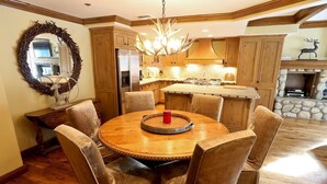 Una cocina con armarios de madera, una isla central y una chimenea de piedra.