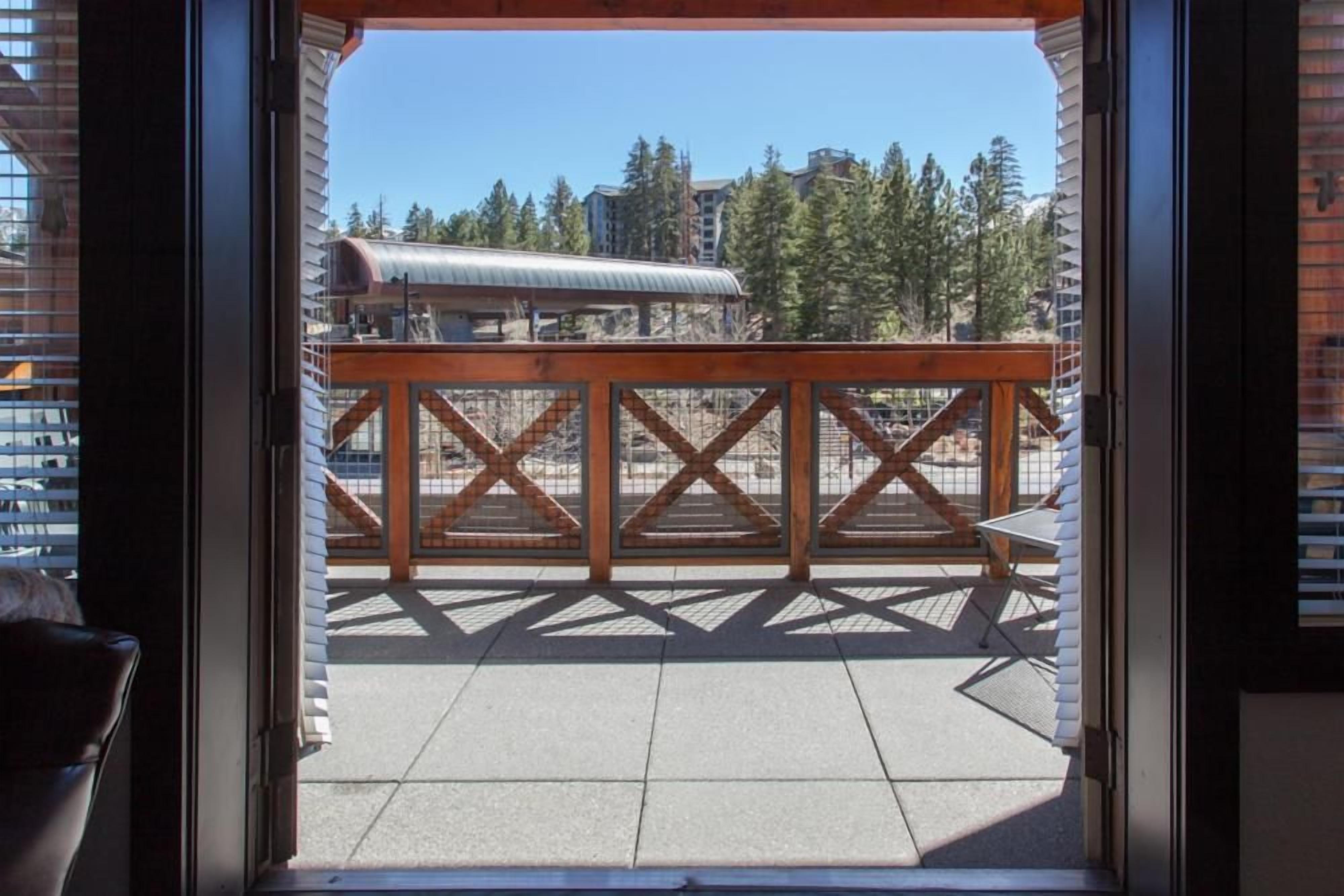 A balcony with a view of a building and trees.