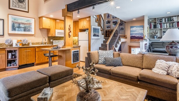 A spacious living area with a sofa, coffee table, and a kitchen in the background. - Chamonix 92 (Mammoth Lakes)