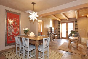A dining area with a wooden table, white chairs, and a star-shaped hanging light fixture.