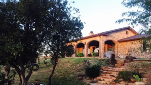 A stone house with a brick exterior, multiple arches, and a stone staircase leading to the entrance. - The LonePine in YellowHouse Canyon (Slaton)