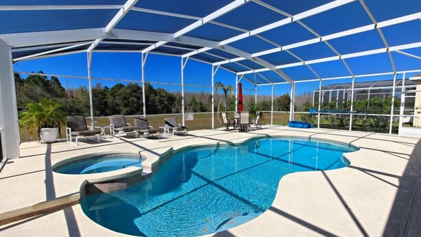 A covered outdoor swimming pool with lounge chairs and a pergola structure. - 351bs 5 Bedroom Villa by RedAwning (Davenport)
