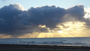 Une plage avec des vagues et un ciel nuageux.