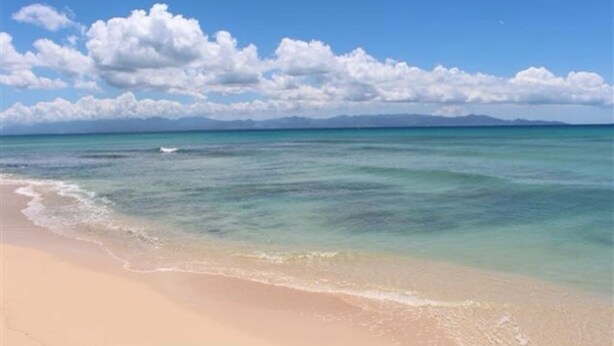Una playa con agua turquesa cristalina y una orilla arenosa.