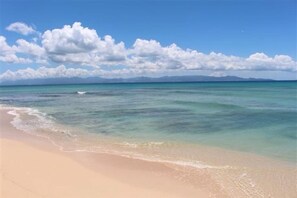 A beach with clear turquoise water and a sandy shore.