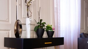 A black console table with gold legs, a white vase, and two potted plants. - Superb 18th century farmhouse, in the heart of the vineyard. (Epfig)