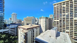 Un immeuble de grande hauteur, doté de nombreux étages et de balcons, se dressant sous un ciel d’un bleu éclatant.