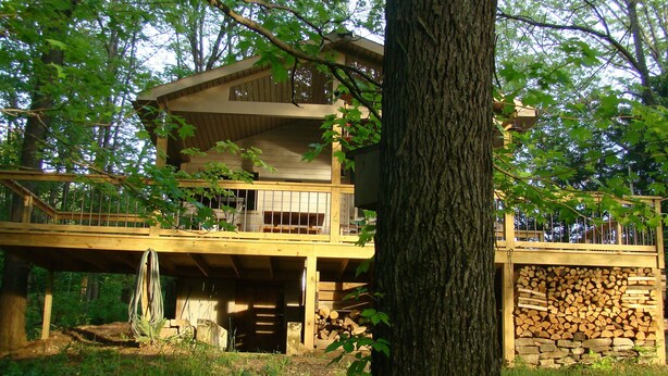 A multi-story wooden cabin with a balcony, surrounded by trees. - Private & unplugged.  Near Fallingwater, GAP and Ohiopyle. 5-star reviews (Fort Hill)