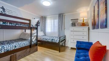Ein Zimmer mit Etagenbetten, einem Schminktisch, einem Stuhl und einer Wand mit motivierenden Sprüchen.